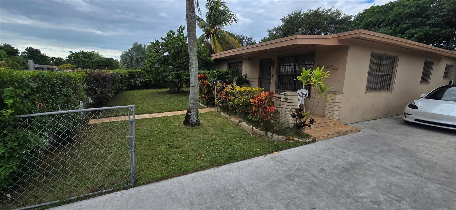 A single-story house with a concrete driveway, a small front lawn, and a covered porch — 17230 NW 10th Court, Miami FL 33169, MIAMI, FL