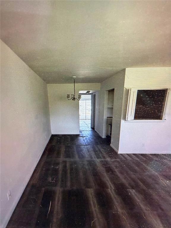 An interior view shows a room with dark wood-look flooring, white walls, and a chandelier — 42 SHEFFIELD B UNIT B, WEST PALM BEACH, FL