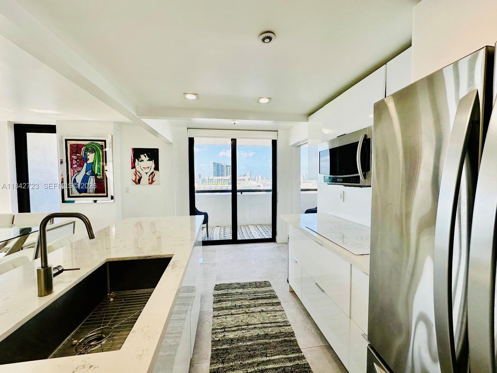 A living and dining area features a sectional sofa, glass tables, and ocean views — 2555 Collins Ave, Miami Beach FL 33140, MIAMI BEACH, FL