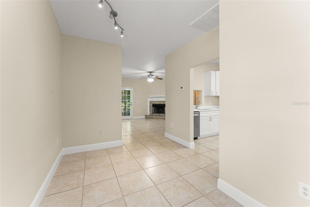 A tiled dining area leads into a living room with a fireplace and a kitchen — 498 DEAN CREEK LANE, ORLANDO, FL
