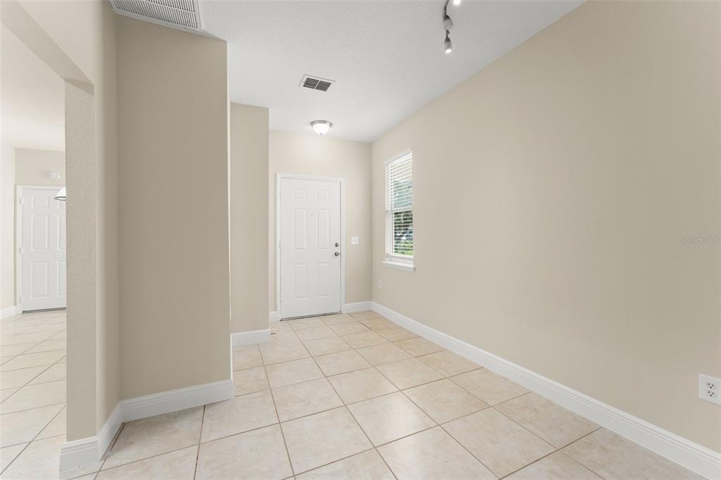 An entryway with beige tile flooring, a white front door, and light-colored walls — 498 DEAN CREEK LANE, ORLANDO, FL