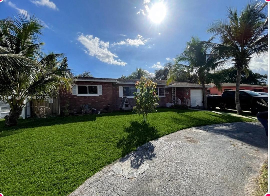 A single-story brick house with a front lawn, palm trees, and a paved driveway — 630 NE 165th St, Miami FL 33162, MIAMI, FL