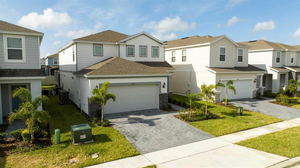 A two-story suburban house with a paved driveway, a two-car garage, and a lawn — 3428 LILAC WAY, DAVENPORT, FL