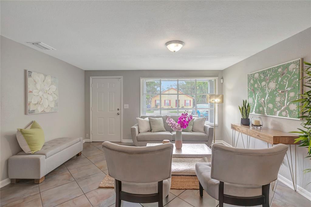 A living room features tile floors, a gray sofa, two armchairs, and a console table — 3908 E HANNA AVENUE, TAMPA, FL