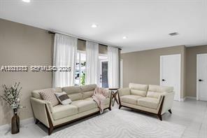 A living room features two beige sofas, white curtains, and light-colored tile flooring — 1540 SE 23rd Ave, Pompano Beach FL 33062, POMPANO BEACH, FL
