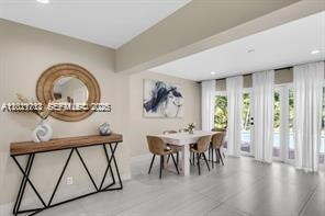 A dining area features a wooden console table, a round mirror, and a table set — 1540 SE 23rd Ave, Pompano Beach FL 33062, POMPANO BEACH, FL