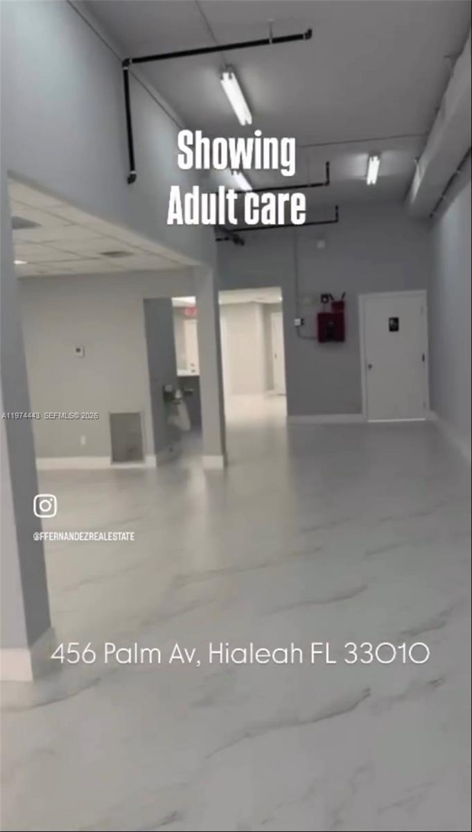 An interior view of a vacant commercial space with light-colored flooring and exposed ceiling pipes — Palm Ave, Hialeah FL 33010, HIALEAH, FL