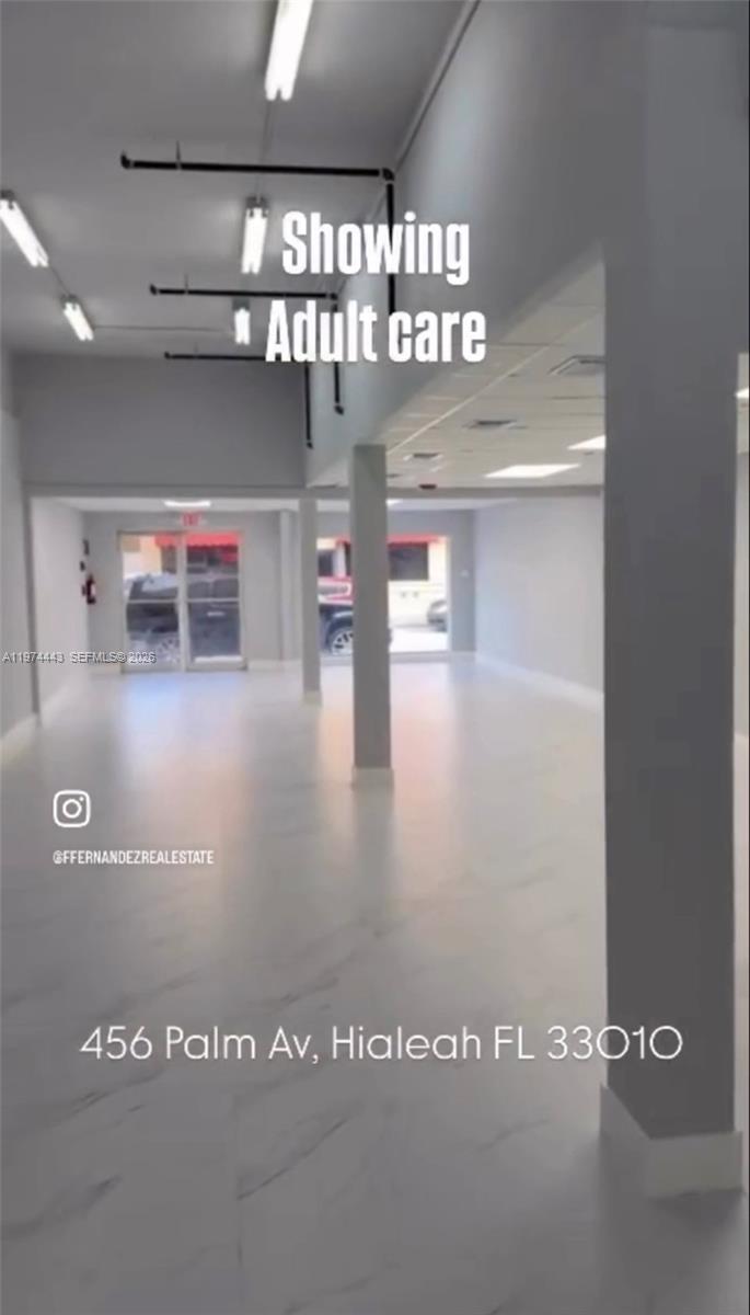 An empty, open-plan commercial space features light-colored tile flooring, white walls, and exposed ceiling pipes — Palm Ave, Hialeah FL 33010, HIALEAH, FL