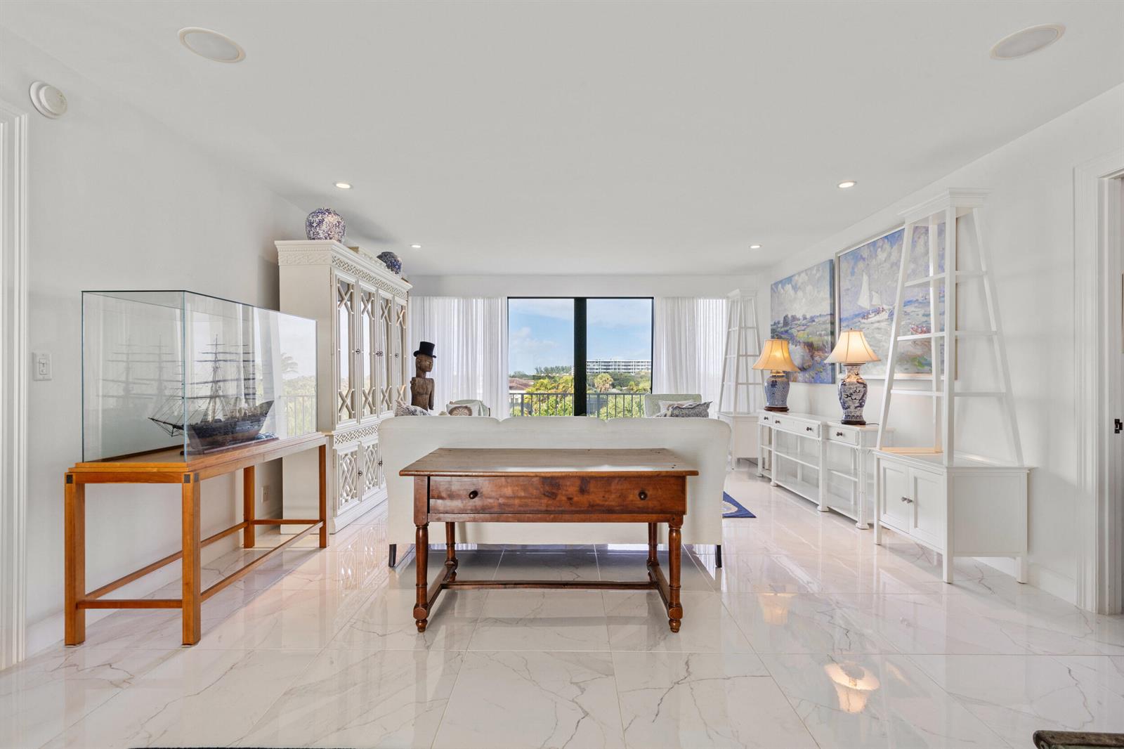 A bright living room features white tile floors, a wooden console table, and a ship model — 2275 S Ocean Boulevard # 307a, Palm Beach FL 33480, PALM BEACH, FL
