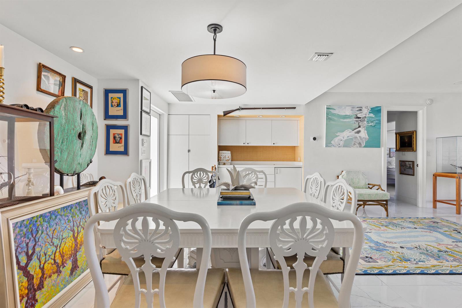 A dining room features a white table, matching chairs, a drum pendant light, and artwork — 2275 S Ocean Boulevard # 307a, Palm Beach FL 33480, PALM BEACH, FL