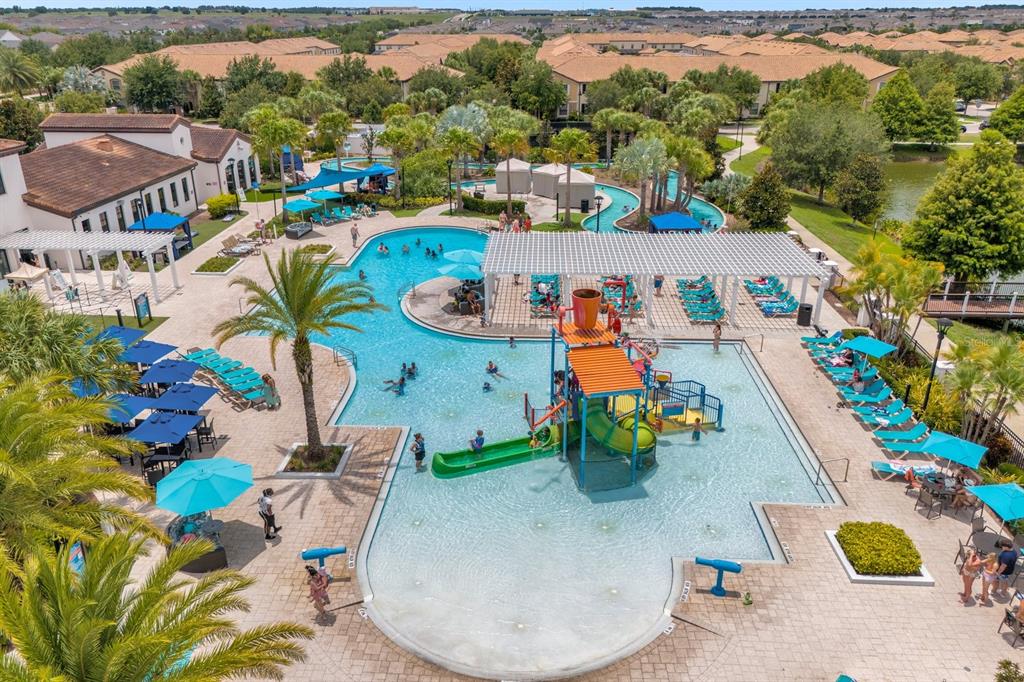 An aerial view of a resort-style swimming pool complex with a water slide and lounge chairs — 8824 BENGAL COURT, KISSIMMEE, FL
