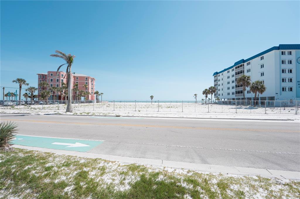 A view of a beachside road with a white sand lot between two multi-story buildings — 800-802 ESTERO BOULEVARD, FORT MYERS BEACH, FL