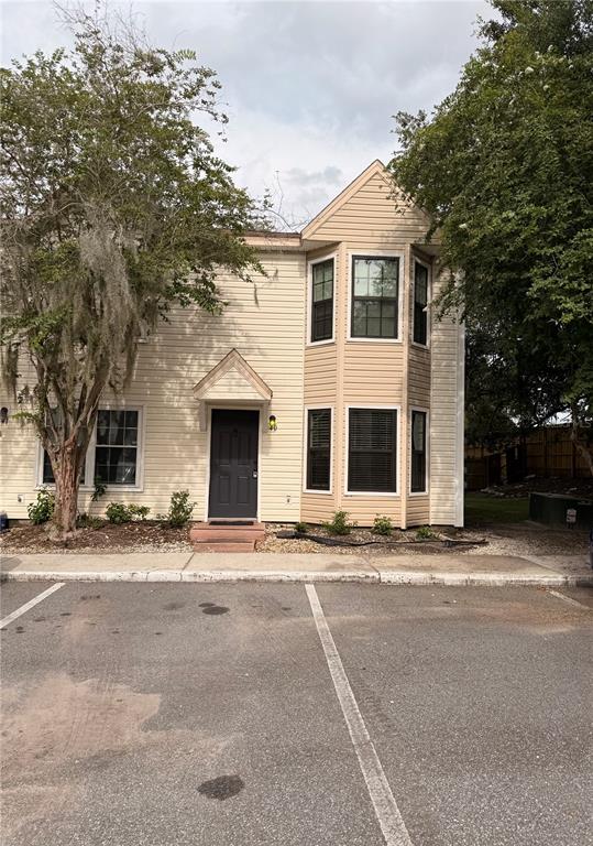 A two-story townhouse with beige siding, a dark front door, and a bay window — 2302 MAKI ROAD UNIT 40, PLANT CITY, FL