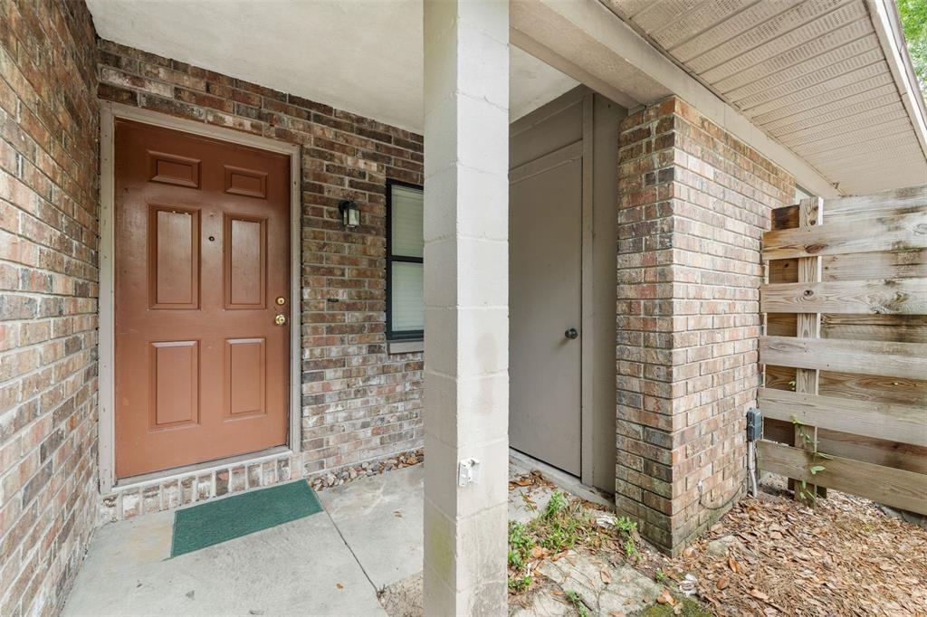A brick exterior entryway features a brown front door, a storage closet, and a post — 3312 NW 52ND TERRACE, GAINESVILLE, FL