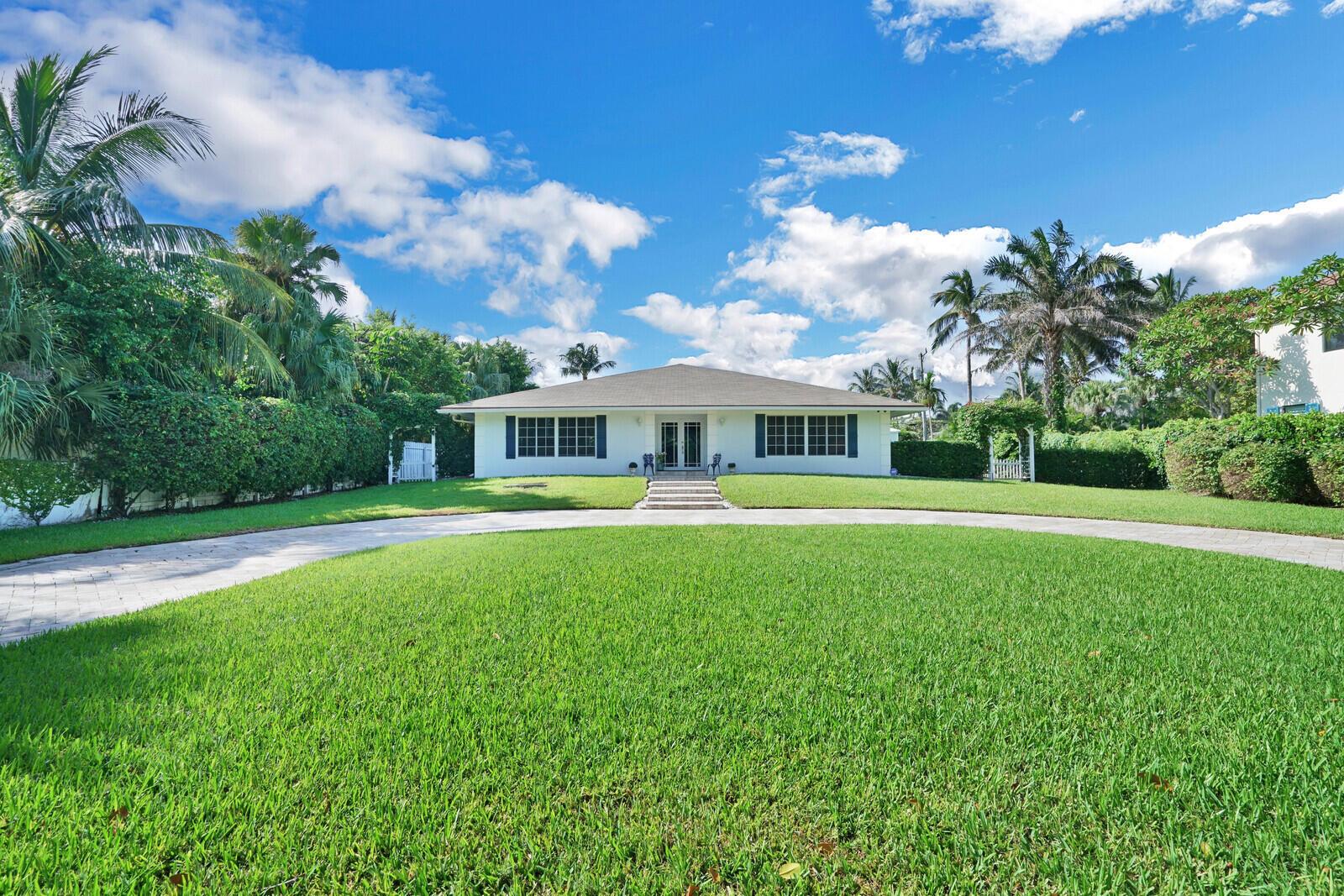 A white single-story house with a circular driveway and palm trees under a blue sky — 17 E Ocean Avenue, Ocean Ridge FL 33435, OCEAN RIDGE, FL