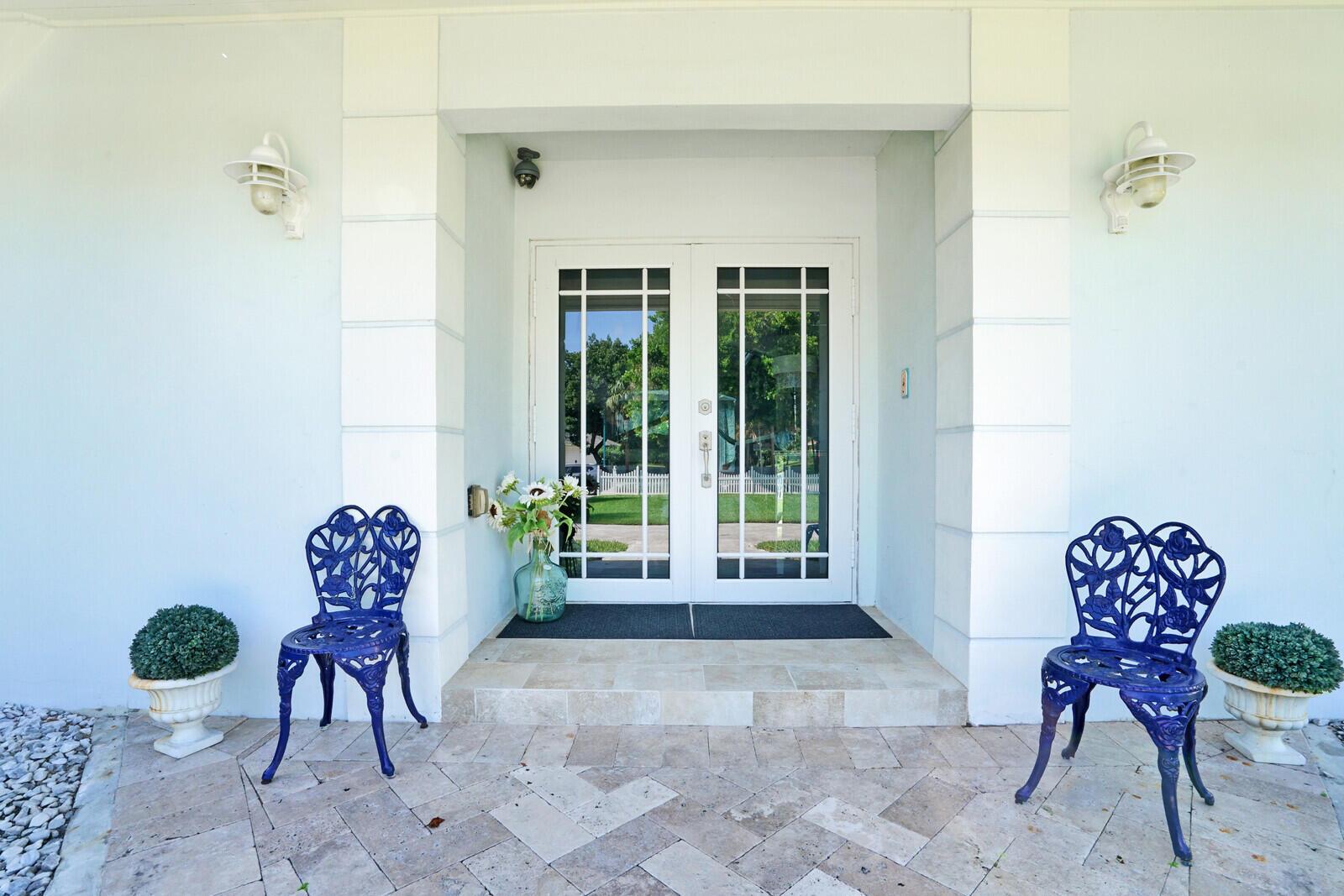A front entryway features double glass doors, two blue metal chairs, and potted greenery — 17 E Ocean Avenue, Ocean Ridge FL 33435, OCEAN RIDGE, FL