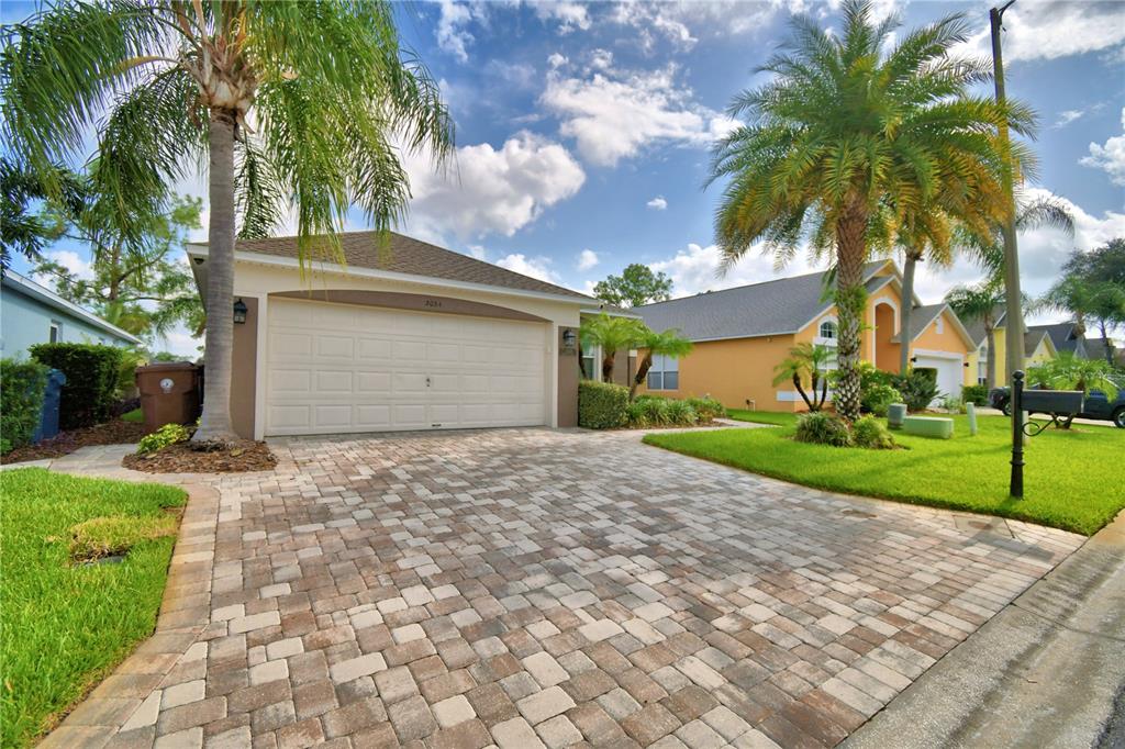 A single-story house with a paved driveway, a two-car garage, and palm trees — 3034 BARBADOS LANE, HAINES CITY, FL