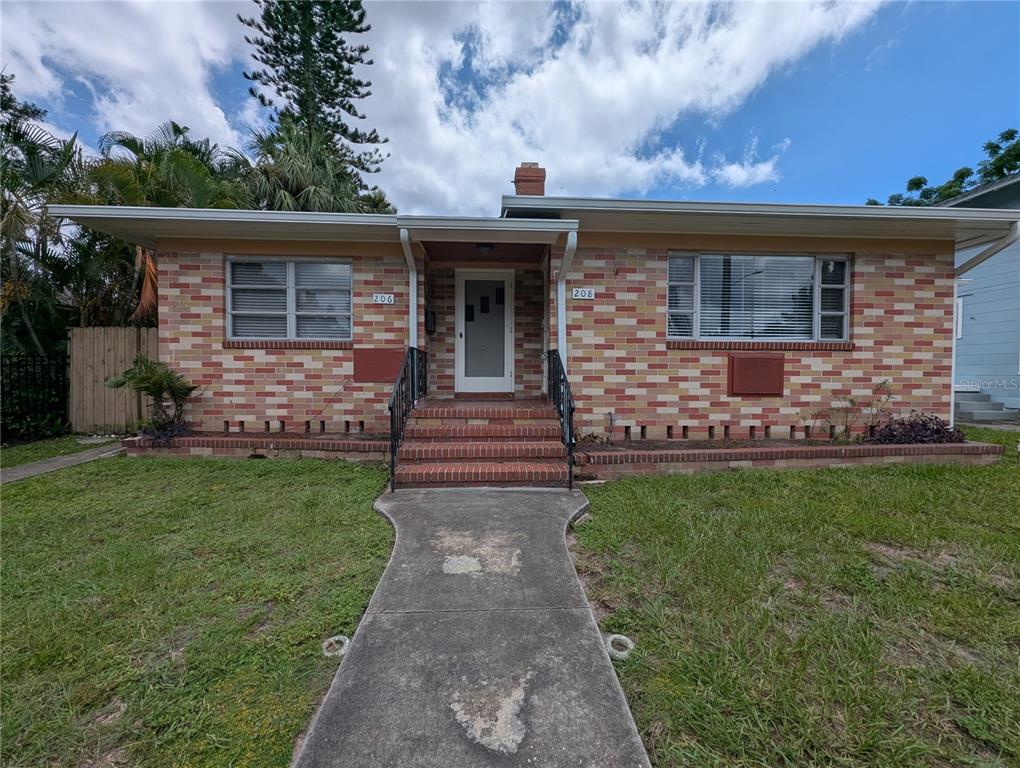 A single-story brick house features a central entryway with stairs and two large front windows — 208 12TH AVENUE N, ST PETERSBURG, FL