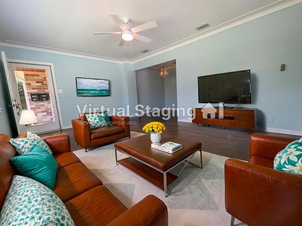 This living room features light blue walls, dark wood floors, and brown leather furniture — 208 12TH AVENUE N, ST PETERSBURG, FL