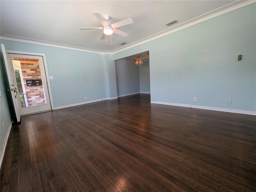 An empty room with light blue walls, dark hardwood floors, and a ceiling fan — 208 12TH AVENUE N, ST PETERSBURG, FL