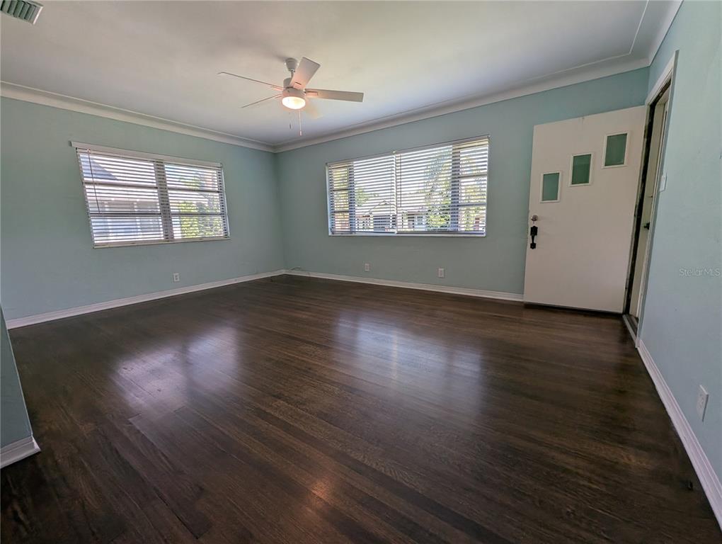 A living room features light blue walls, dark hardwood floors, and a ceiling fan — 208 12TH AVENUE N, ST PETERSBURG, FL