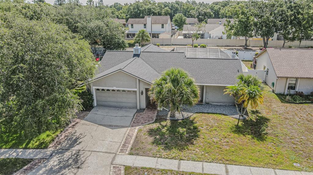 An aerial view shows a single-story house with a gray roof, garage, and palm trees — 6728 RANGER DRIVE, TAMPA, FL