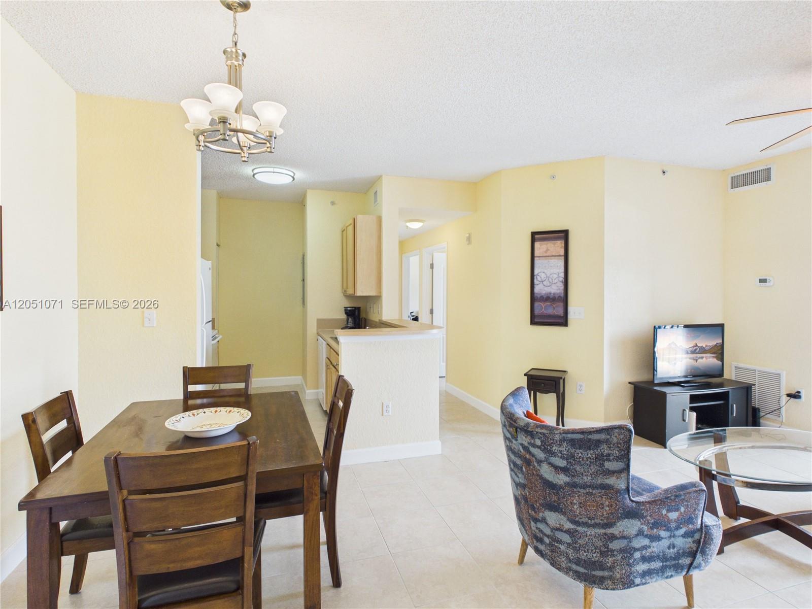 A dining area with a wooden table and chairs sits adjacent to a kitchen counter — 6001 SW 70th St # 502, South Miami FL 33143, SOUTH MIAMI, FL