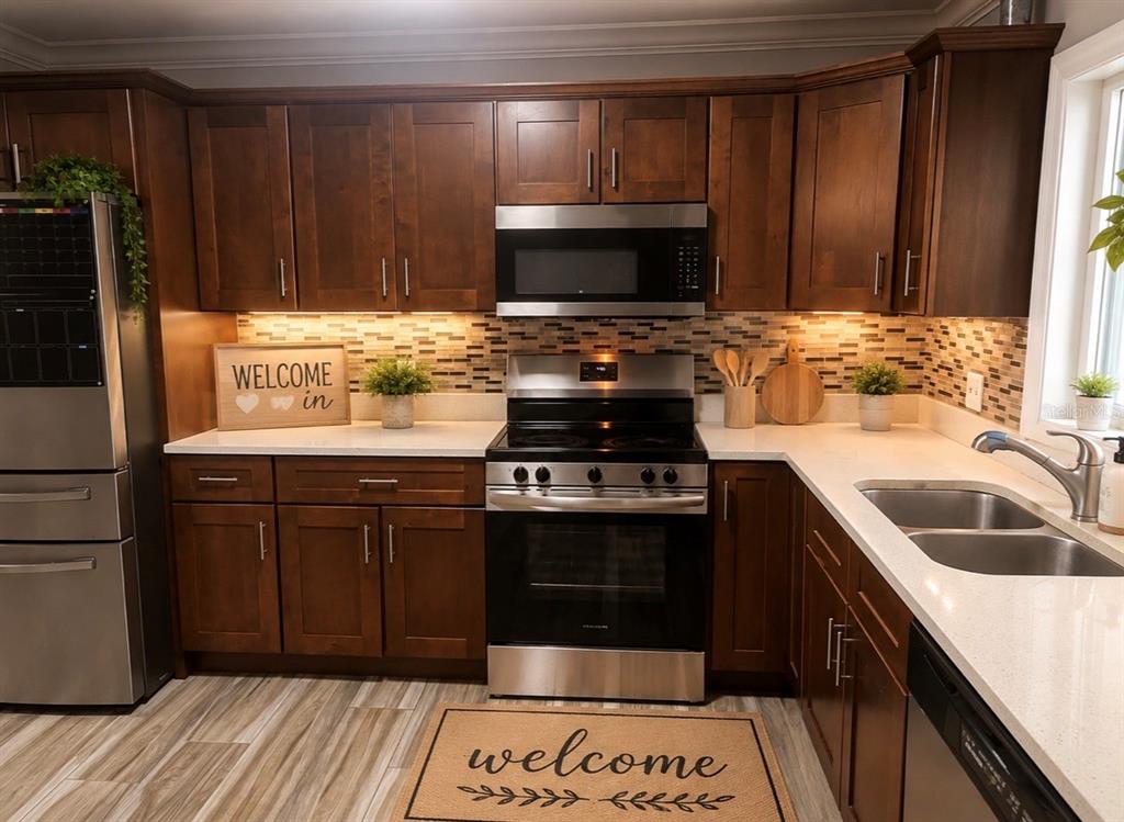 A kitchen features dark wood cabinets, stainless steel appliances, and a white countertop — 1623 WAVECREST STREET, MERRITT ISLAND, FL