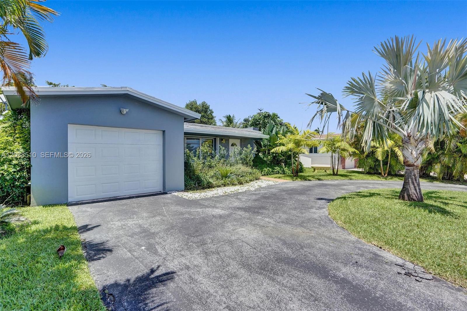 A single-story house with a white garage door and a curved asphalt driveway — 4519 Monroe St, Hollywood FL 33021, HOLLYWOOD, FL