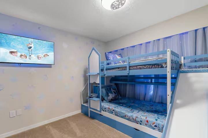 A children's bedroom features a blue bunk bed, a wall-mounted television, and themed wall decals — 4030 LANA AVENUE, DAVENPORT, FL