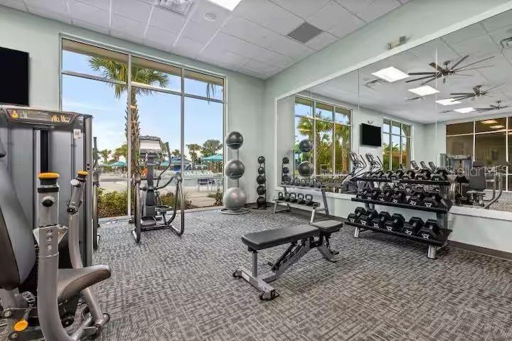A fitness center features exercise equipment, a weight rack, a bench, and large windows — 4030 LANA AVENUE, DAVENPORT, FL