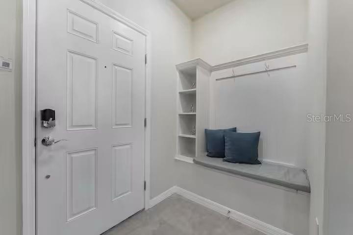 An entryway features a white door, a built-in bench with cushions, and open shelving — 4030 LANA AVENUE, DAVENPORT, FL