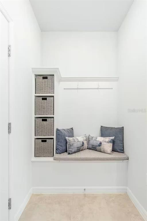 A mudroom nook features a built-in bench with storage baskets and a wall-mounted coat rack — 4030 LANA AVENUE, DAVENPORT, FL