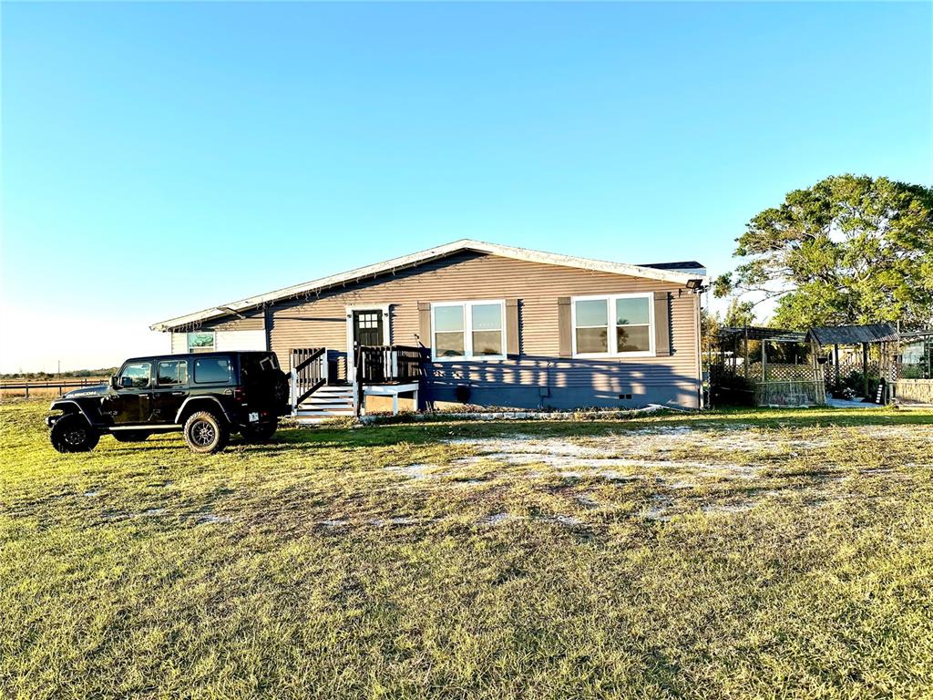 A single-story house with gray siding and a black Jeep parked in the front yard — 35495 SINGLETARY ROAD, MYAKKA CITY, FL
