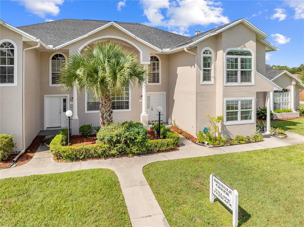 A two-story tan stucco townhouse features a palm tree in the front garden — 3078 SHINGLE CREEK COURT, KISSIMMEE, FL