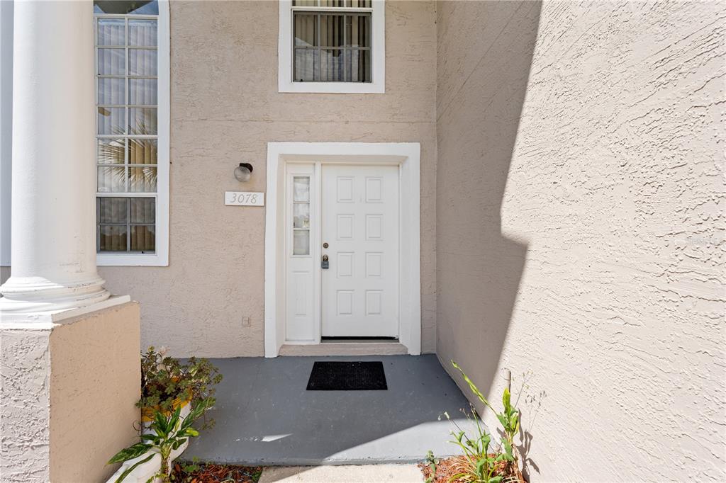 The exterior view shows a white front door with a sidelight and a house number — 3078 SHINGLE CREEK COURT, KISSIMMEE, FL