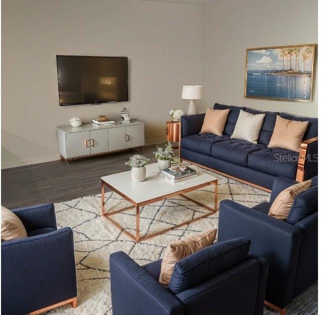 A living room features a navy sofa and chairs with rose gold accents and decor — 1040 MELVILLE ROAD, PUNTA GORDA, FL