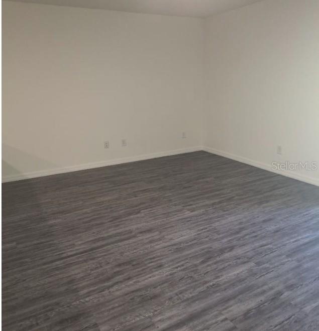 An empty room with white walls and gray wood-look flooring — 1040 MELVILLE ROAD, PUNTA GORDA, FL