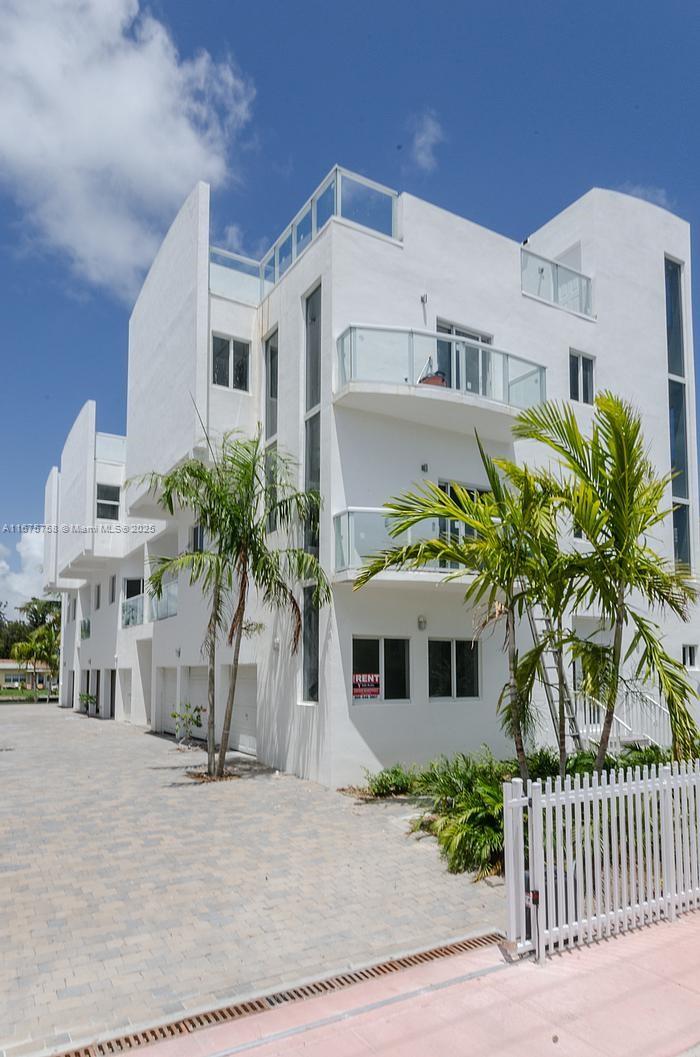 A multi-story white modern building with balconies and a paved driveway under a blue sky — 1975 Calais Dr, Miami Beach FL 33141, MIAMI BEACH, FL