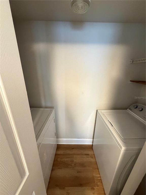 A laundry closet contains a white washer and dryer on a wood-look floor — 11520 WESTWOOD UNIT 527, ORLANDO, FL
