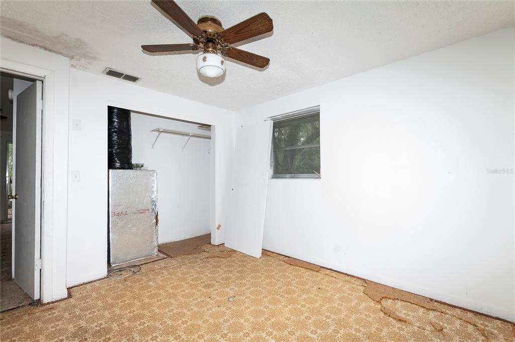 An empty bedroom features a ceiling fan, a closet with an exposed HVAC unit, and carpet — 3596 W IVY STREET, DUNNELLON, FL