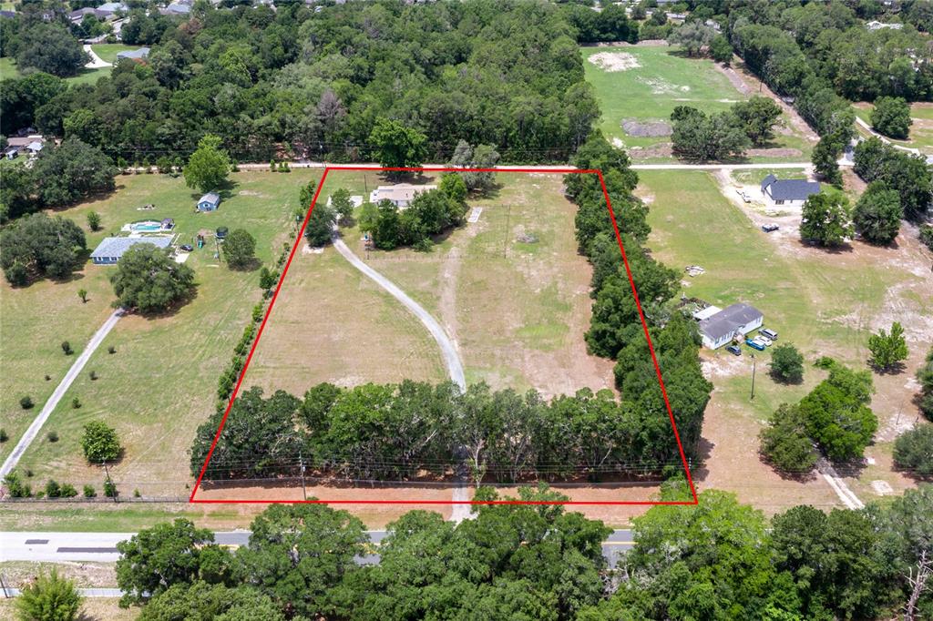 An aerial view shows a house on a large, rectangular lot outlined in red — 7416 SW 75TH STREET, GAINESVILLE, FL