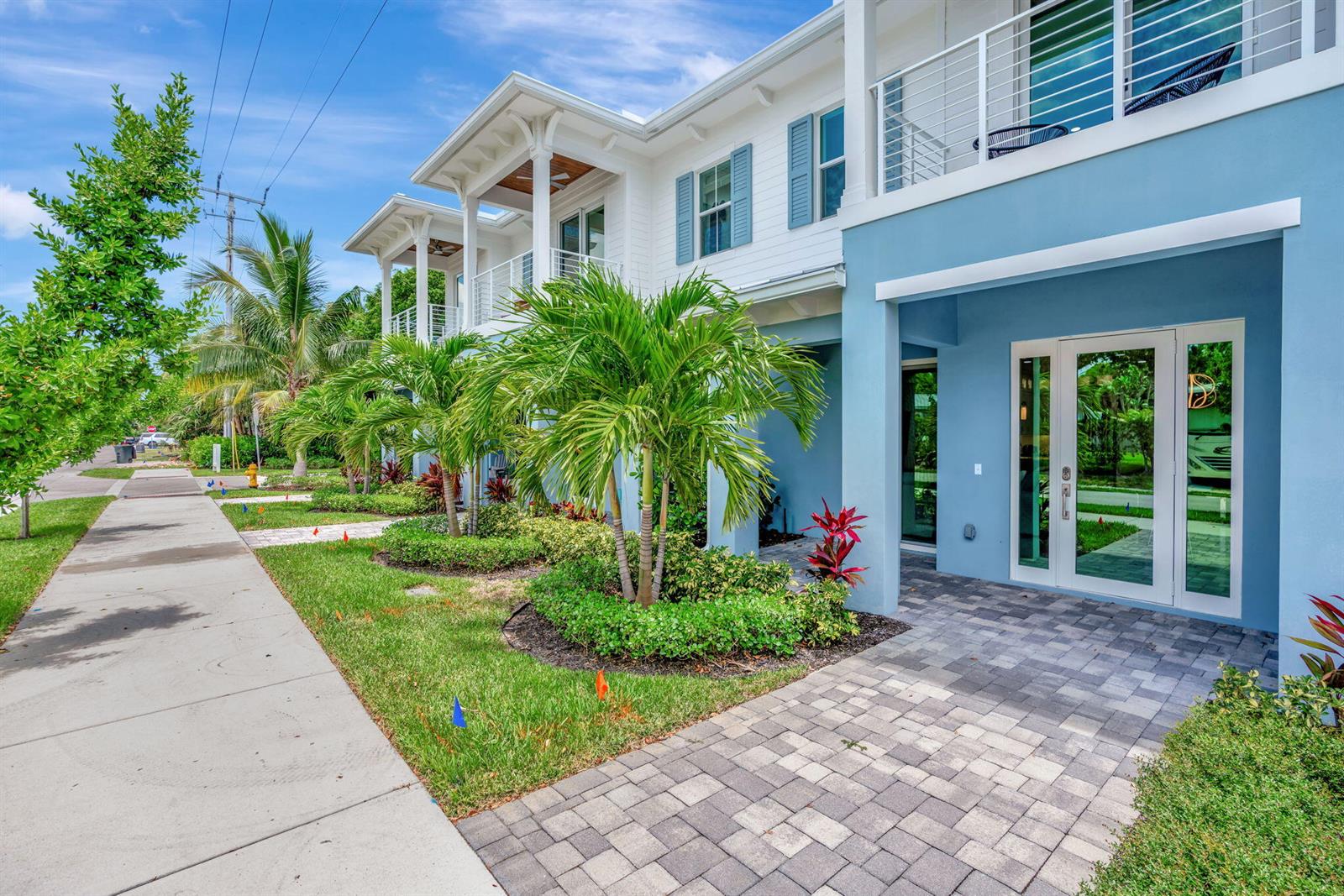 A blue and white multi-story building features a paved walkway and palm trees in front — 4662 SE Manatee Way, Stuart FL 34997, STUART, FL