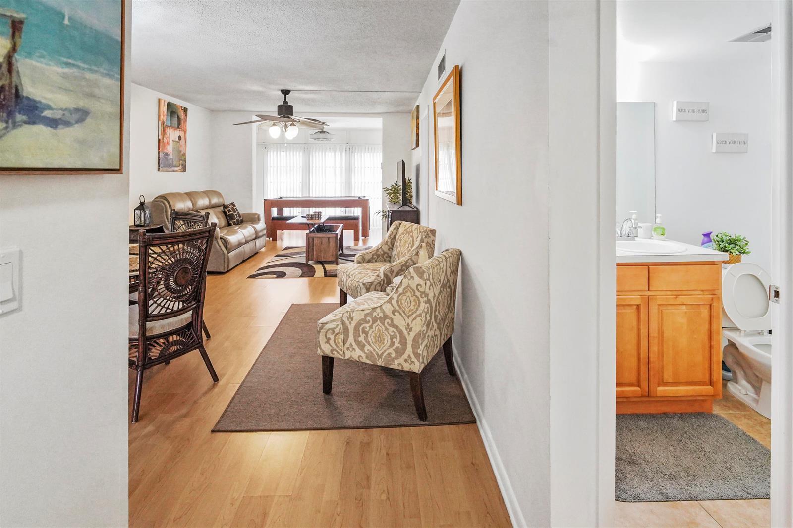 A view from a doorway looking into a living area with two patterned armchairs — 6650 Royal Palm Boulevard # 104c, Margate FL 33063, MARGATE, FL