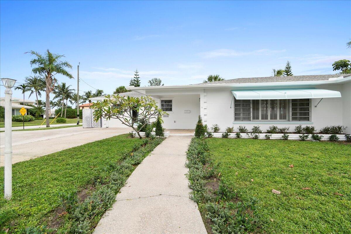 A white single-story house with a concrete walkway and a green lawn — 2412 N Lakeside Drive, FL 33460, FL