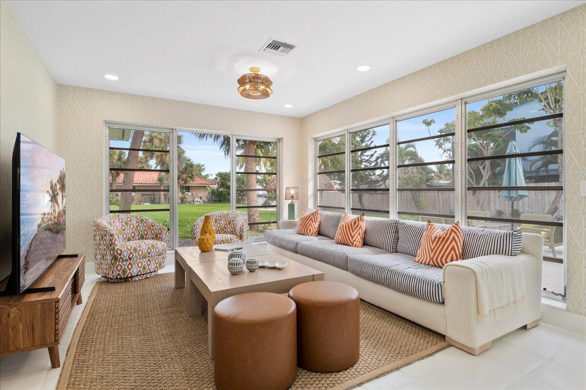 A living room features a striped sofa, patterned armchairs, a coffee table, and large windows — 2412 N Lakeside Drive, FL 33460, FL