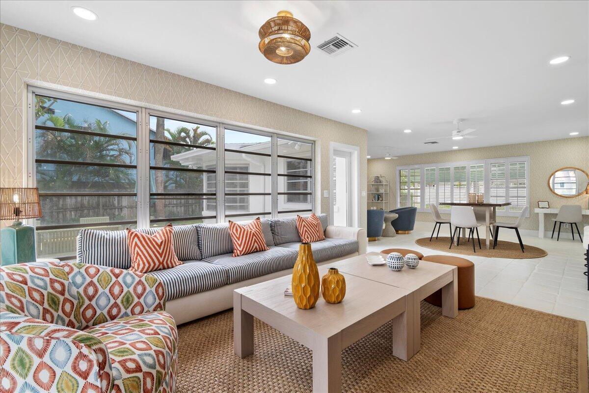 A living room features a striped sofa, patterned armchair, coffee tables, and large windows — 2412 N Lakeside Drive, FL 33460, FL