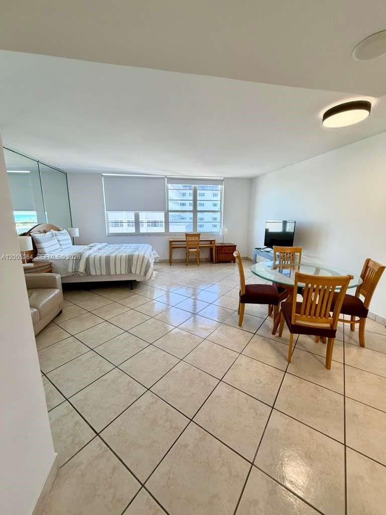 A studio apartment features a bed, dining set, desk, and tile flooring — 100 Lincoln Rd # 731, Miami Beach FL 33139, MIAMI BEACH, FL