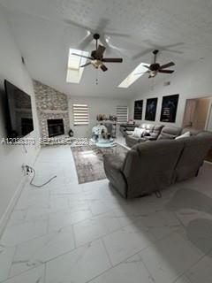 A living room features a stone fireplace, two ceiling fans, skylights, and white tile floors — 209 42nd St., Cape Coral FL 33914, CAPE CORAL, FL