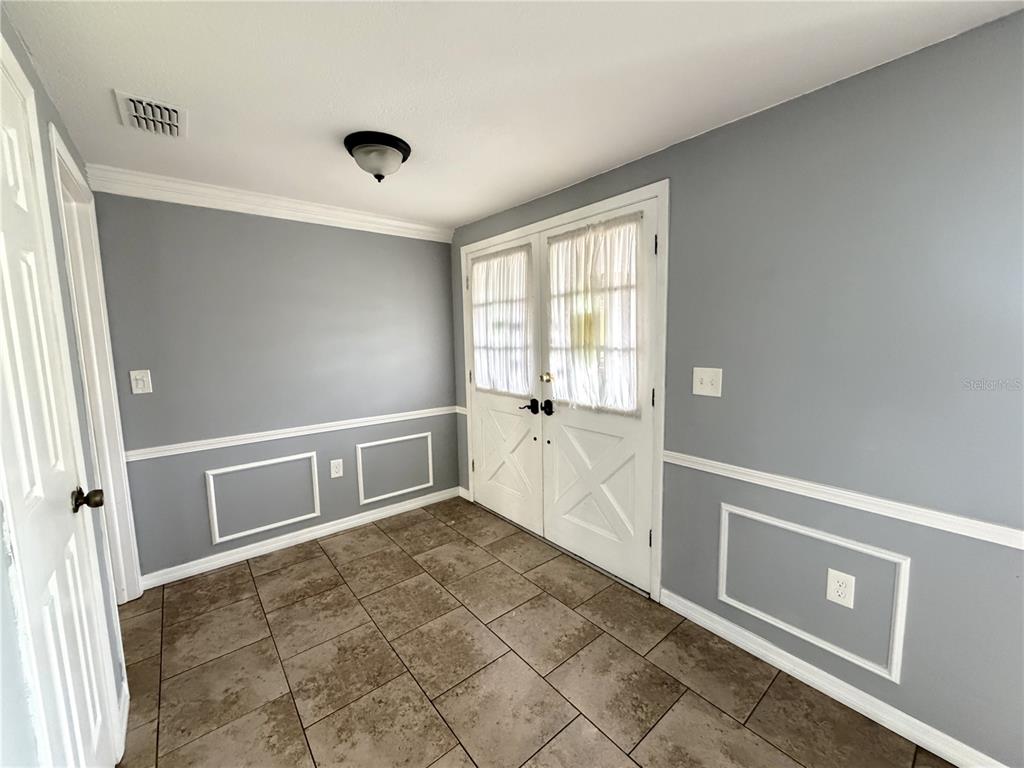An entryway features gray walls with white wainscoting, tile flooring, and white double doors — 12407 WEATHERSTONE ROW, HUDSON, FL